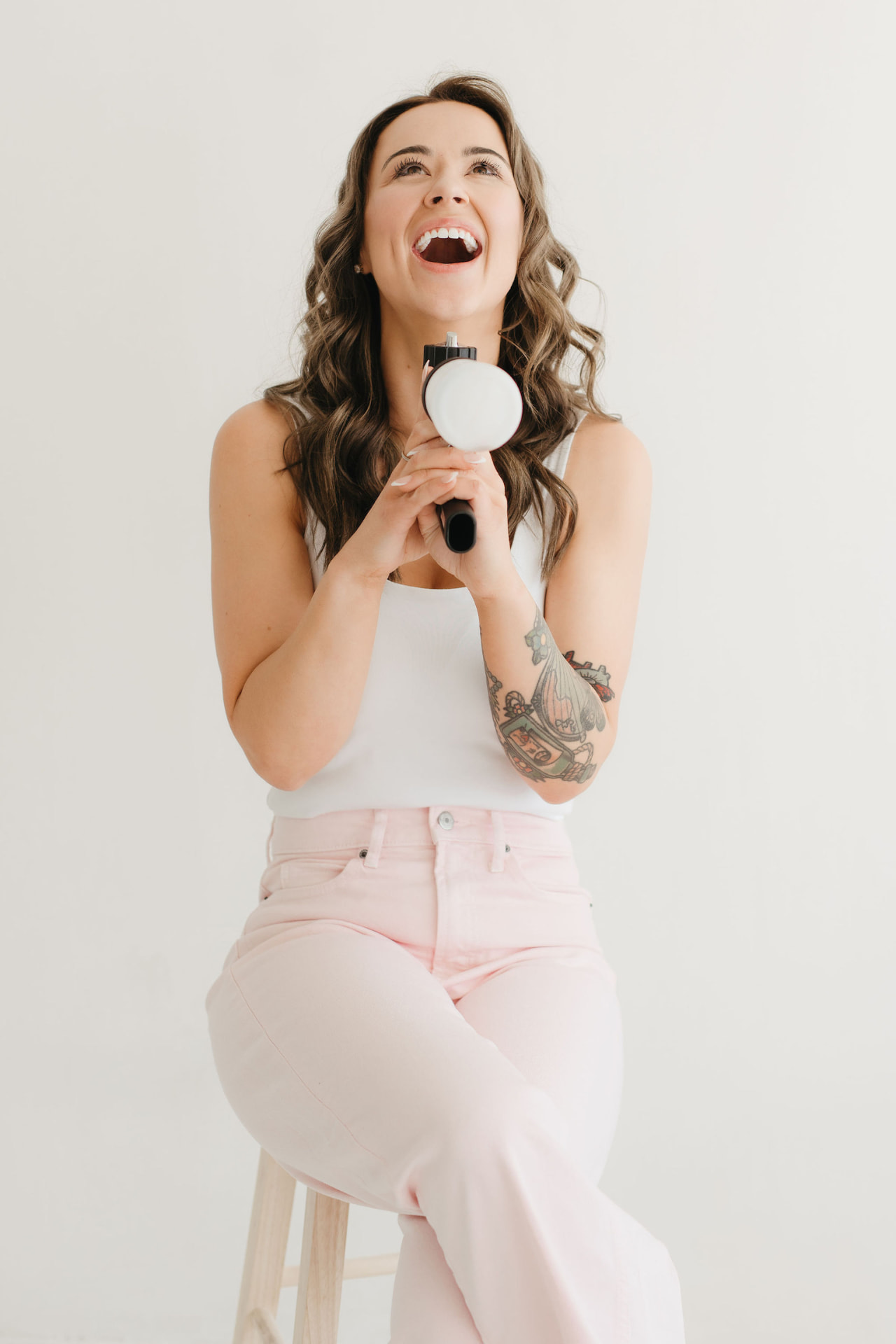 Mackenzie laughing while holding a paint sprayer, Mackenzie, Assistant at Summers Painting