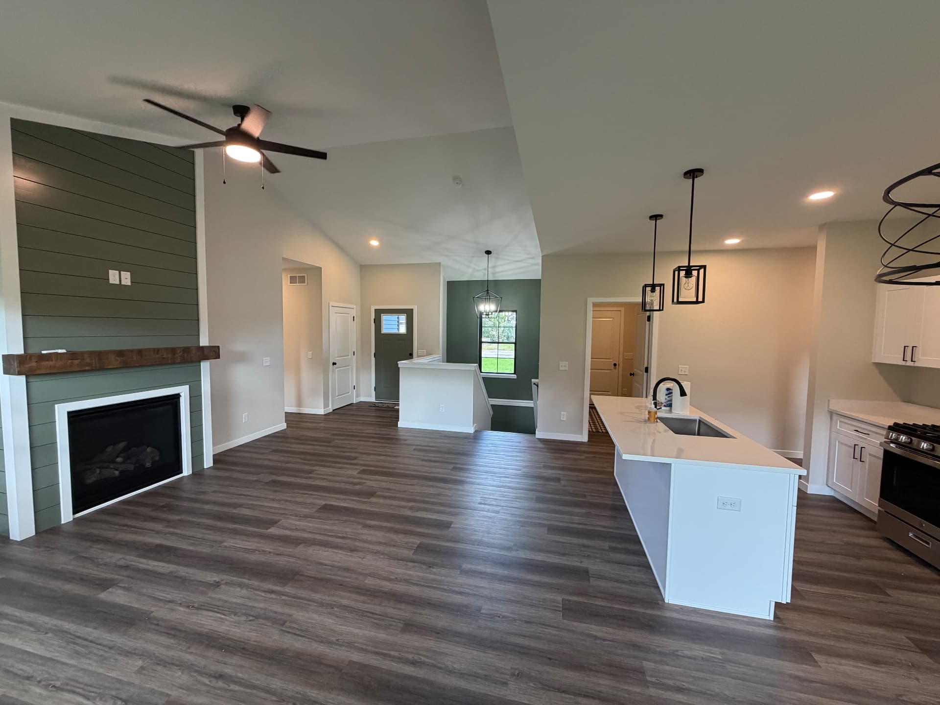 Freshly painted open concept great room with green shiplap fireplace wall in Orfordville, Wisconsin