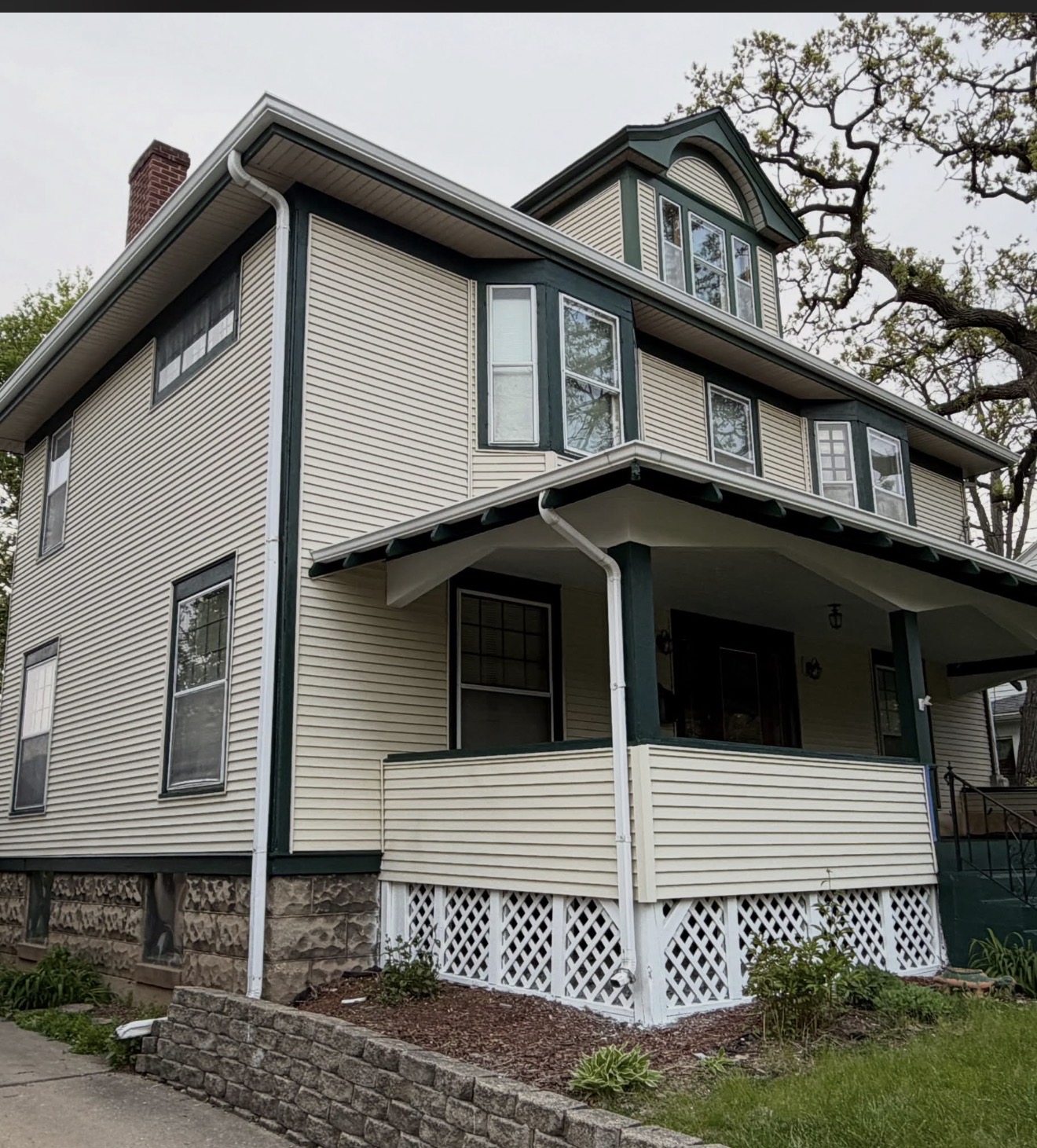 Cream residential exterior with dark green trim