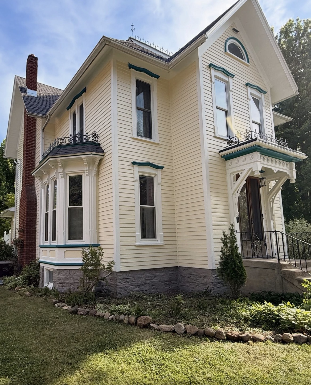 Yellow Victorian home exterior painting with green trim
