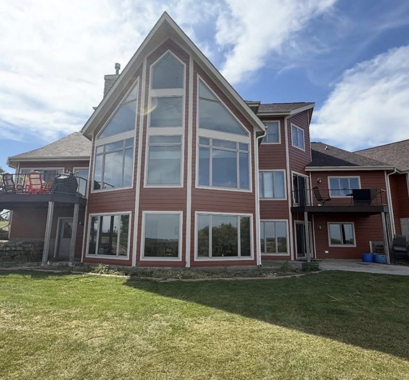 Red lakeside residential exterior with peaked glass wall painting