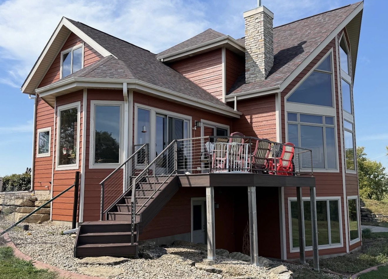 Red residential exterior with deck and stone chimney repaint