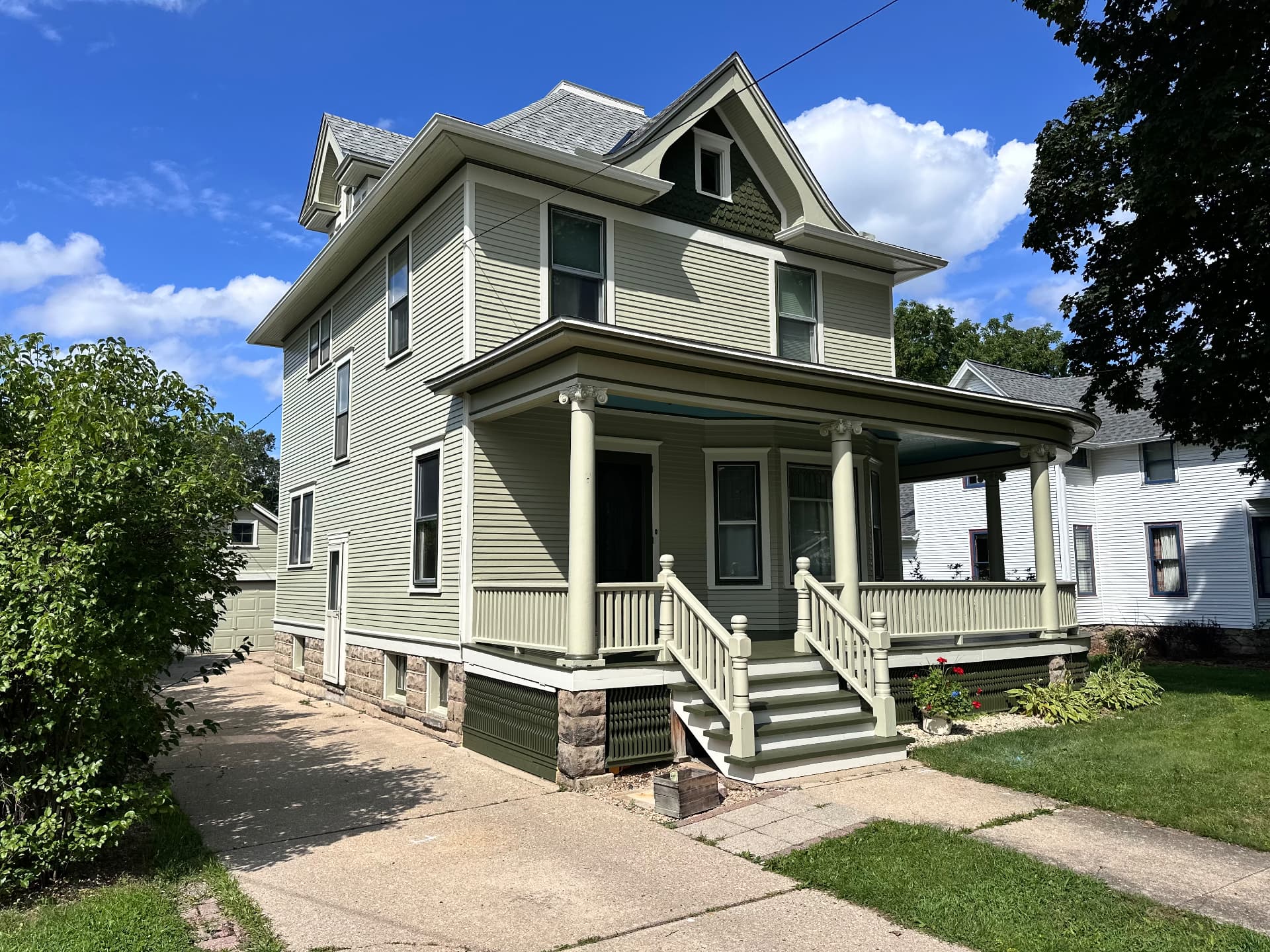 Historic Victorian home with fresh sage green exterior paint in Evansville, Wisconsin